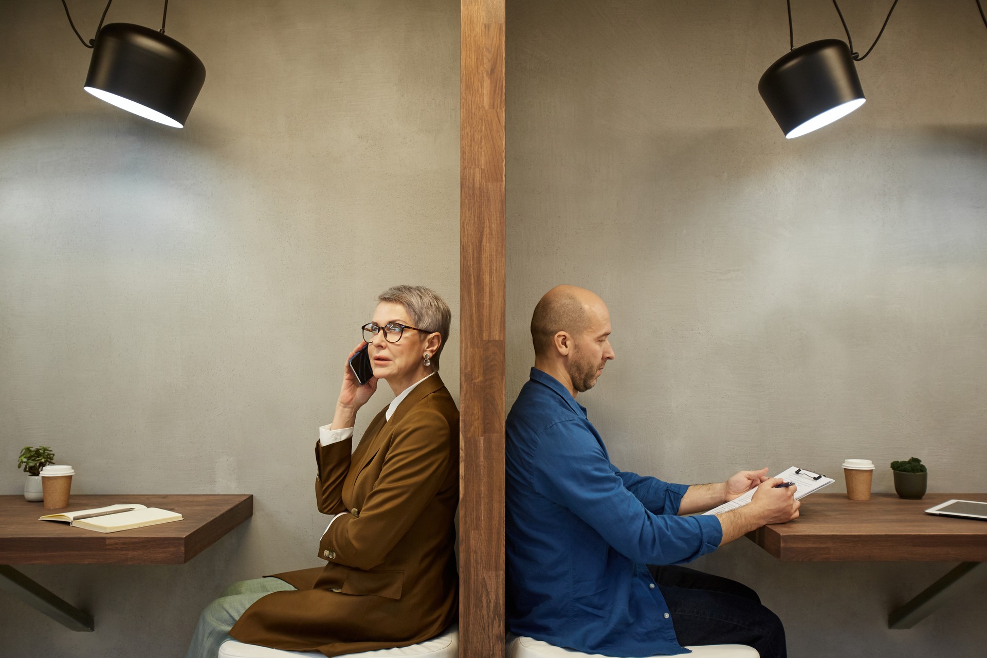 Business People Separated by Wall in Cafe